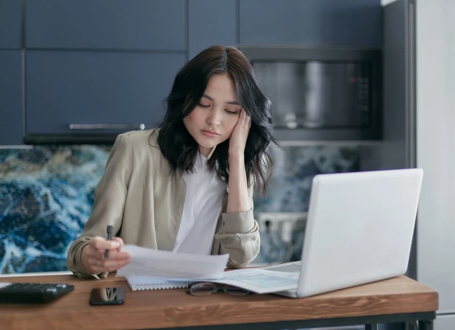 집에서 서류와 노트북으로 경비를 정리하는 모습