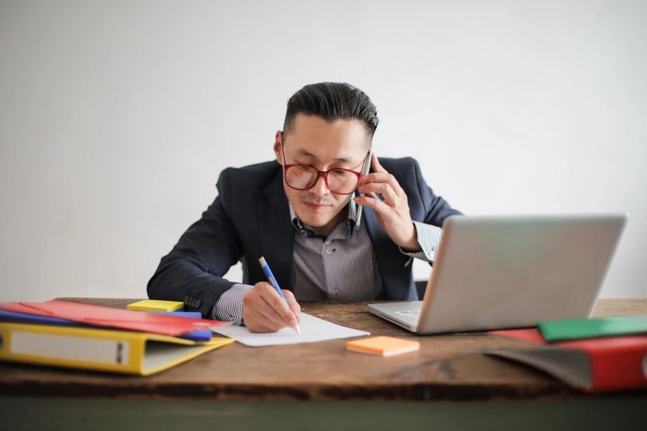 전화로 상담하며 메모하는 사람